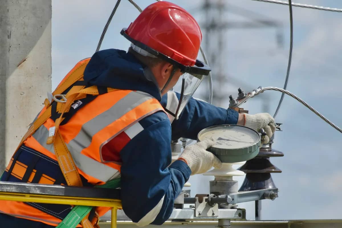Técnico con arnés y casco trabajando en equipo de altura